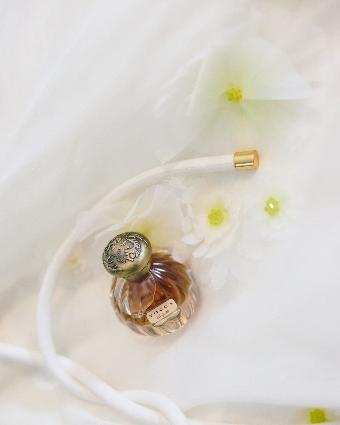 Bottle of perfume on a white sheet.