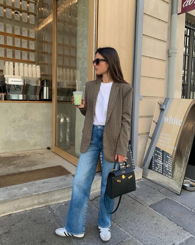 @leasy_inparis wears a pair of straight-leg blue jeans, trainers and a checked blazer