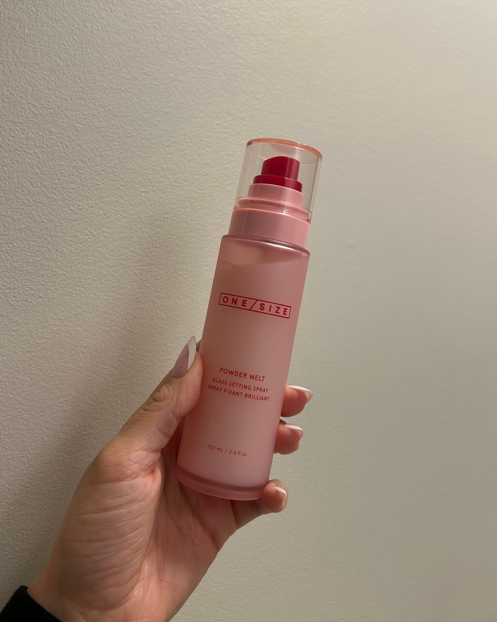 Alyssa Brascia holding the One/Size Powder Melt Glass Setting Spray.