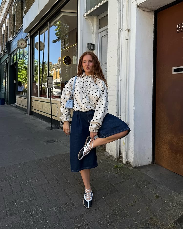 @rebeccaferrazwyatt wears a pair of ballet-style trainers with long shorts and a lightweight polkadot jacket