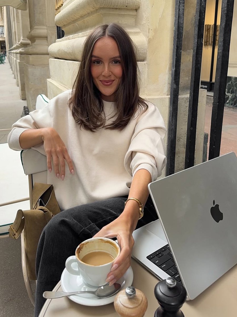 Emma Leger drinks coffee while working at a cafe in Paris.