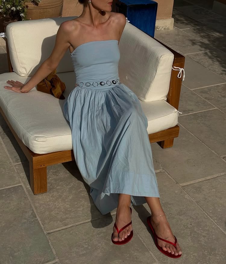 @chloekathbutler wears a pair of red satin flip flops with a blue dress and a studded belt
