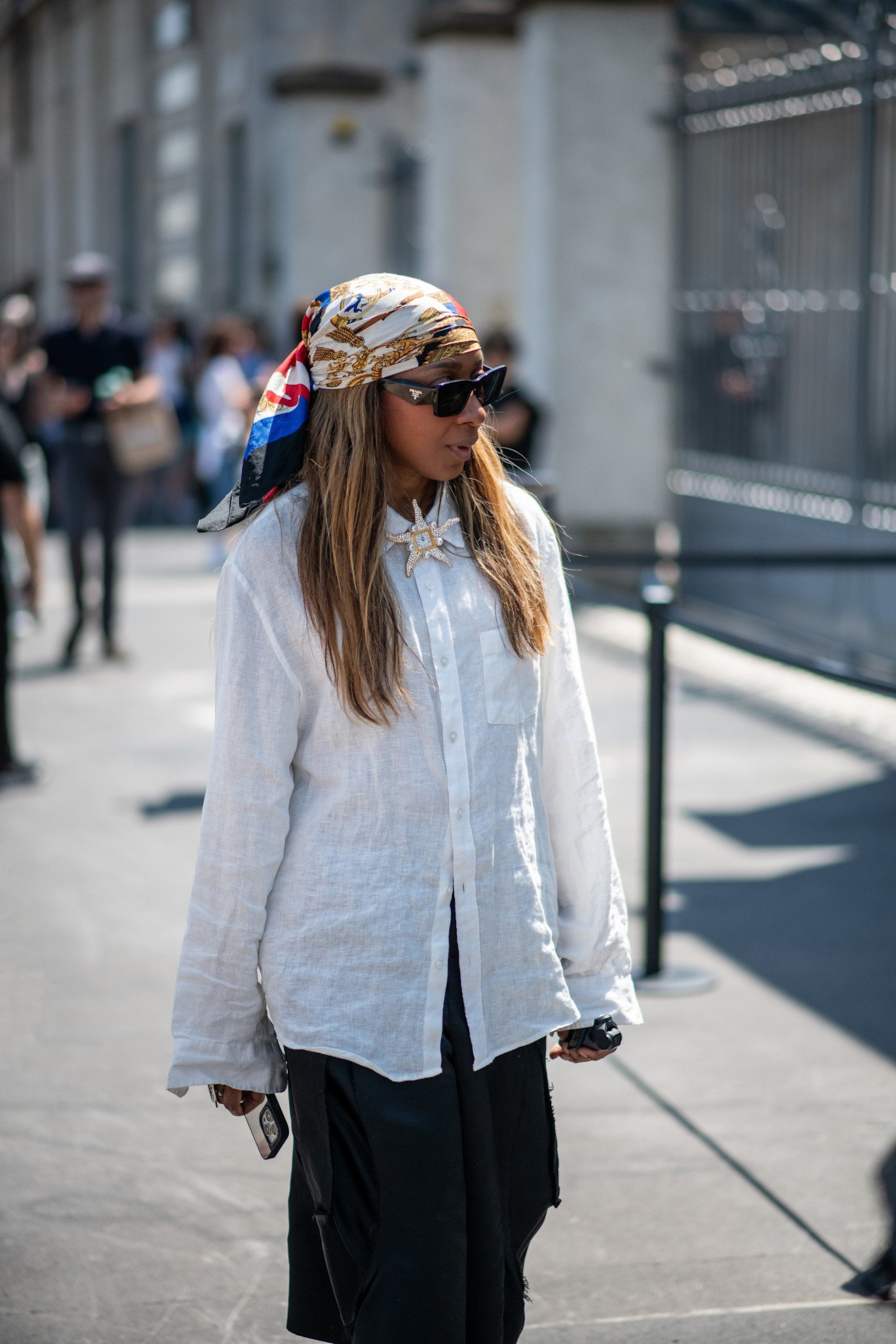 Milan Mens Fashion Week Showgoer wears a headscarf over her hair outside on the streets in Milan.