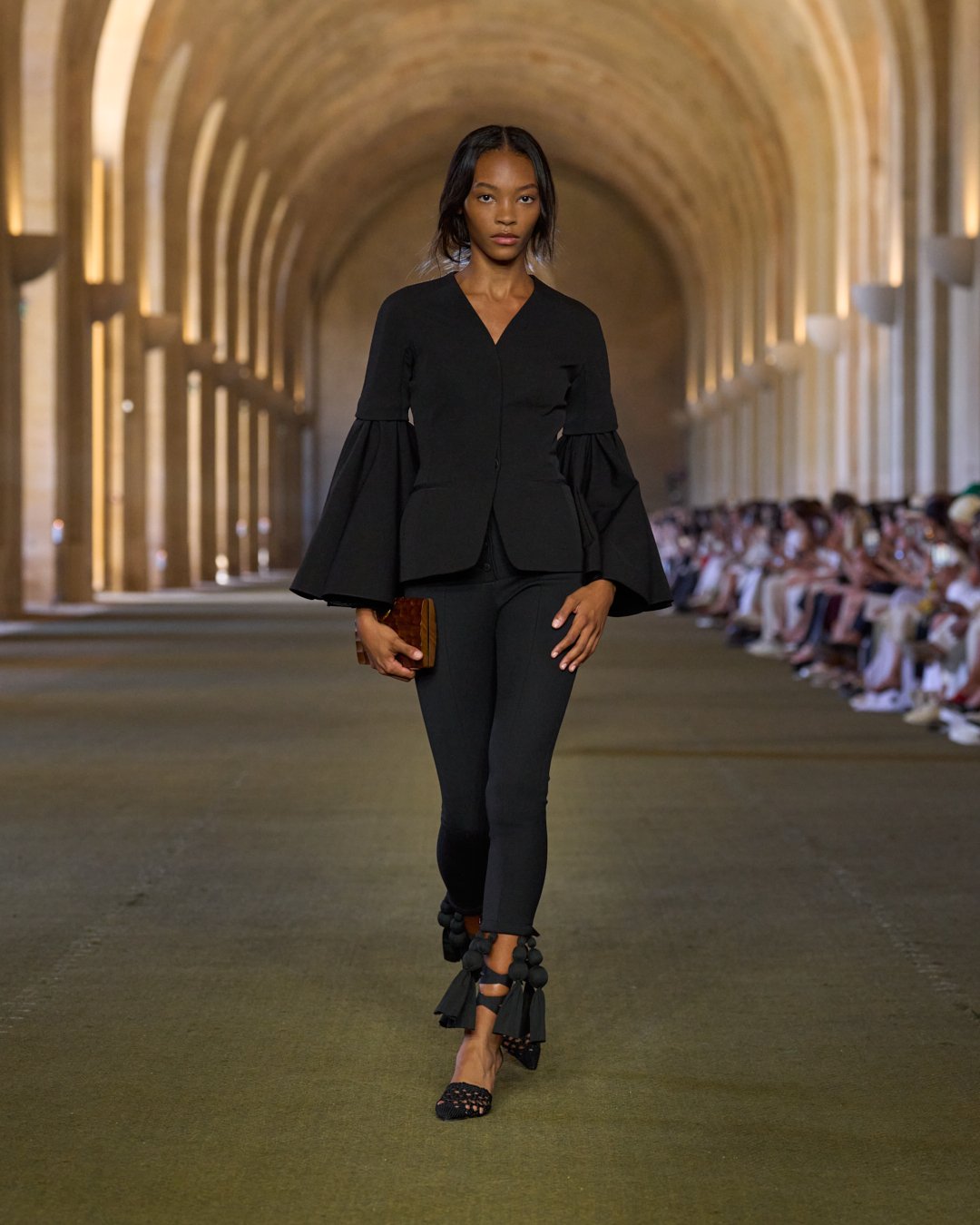 a woman walks the jacquemus show.