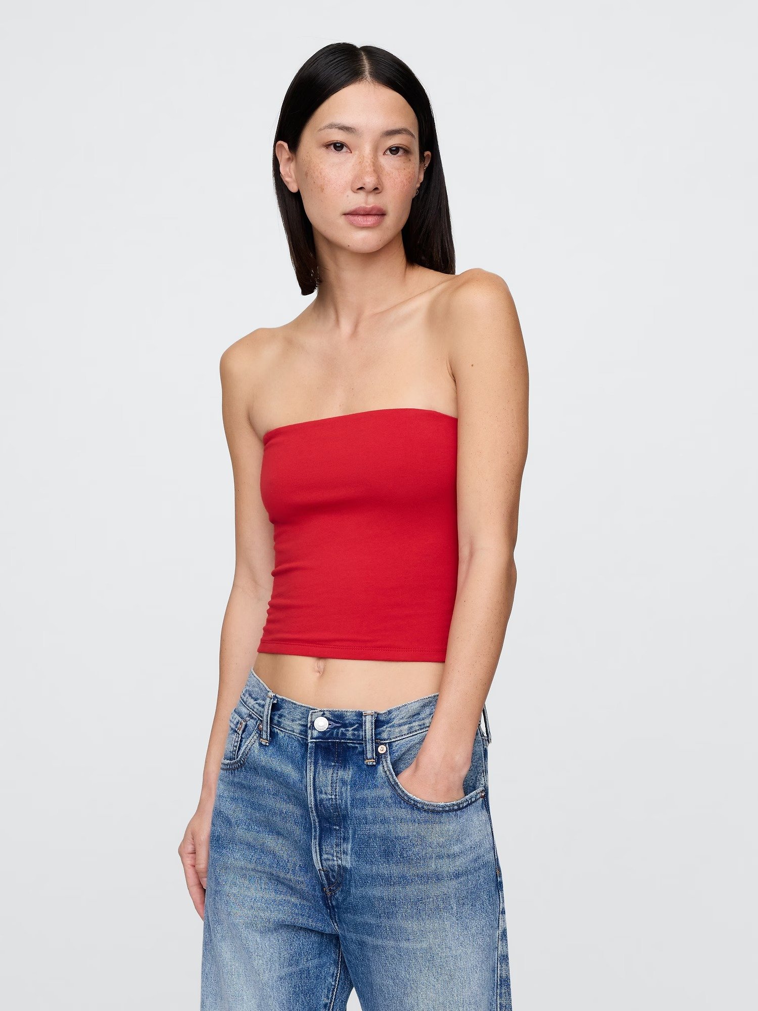 Woman wearing a red tube top and blue jeans