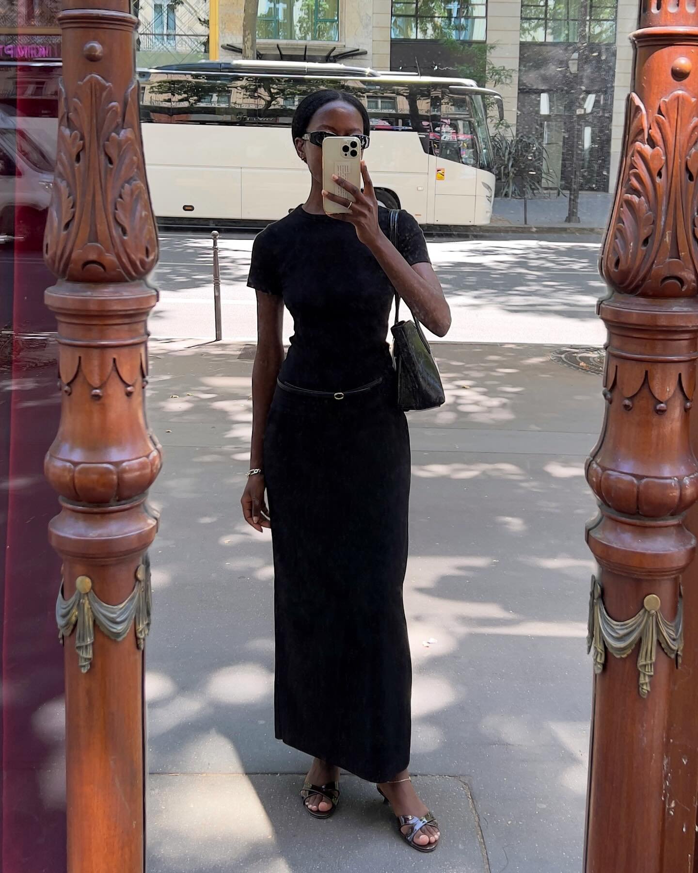 @sylviemus_ wears patent leather slider sandals with a black maxi skirt and T-shirt