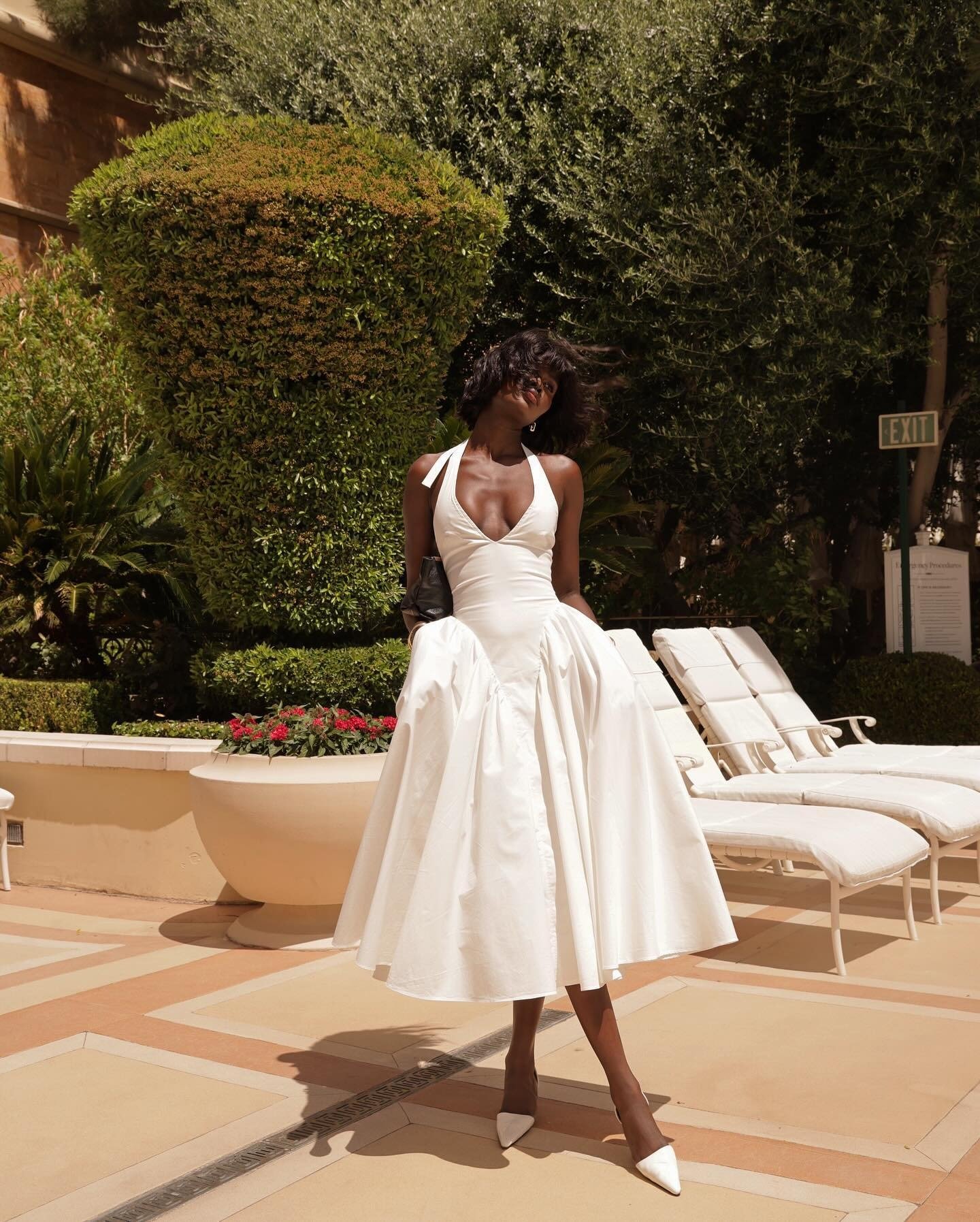 Amy Julliette Lefévre wears halterneck white dress in Las Vegas by the pool.