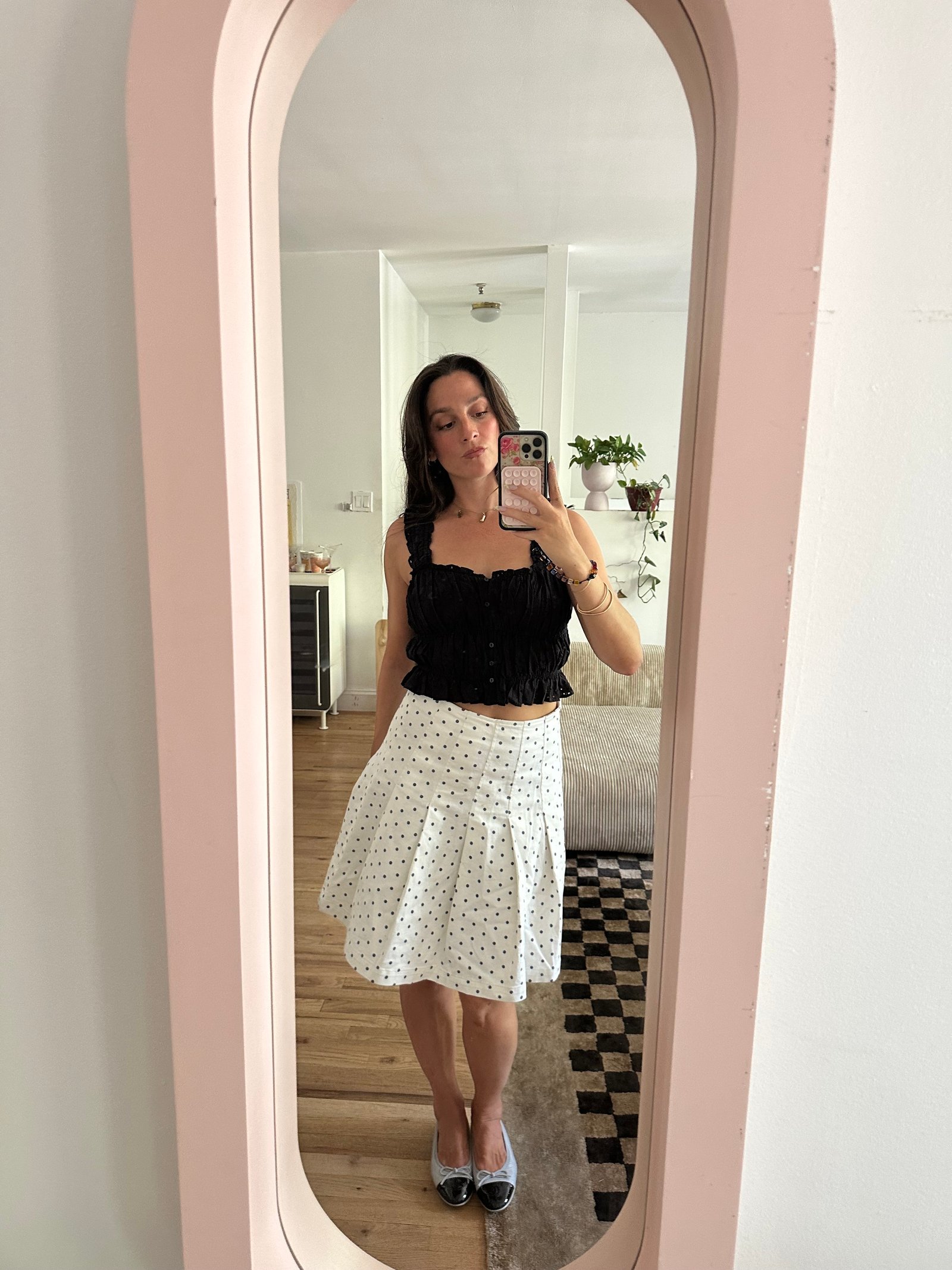 Tara Gonzalez taking selfies in a polka dot skirt.