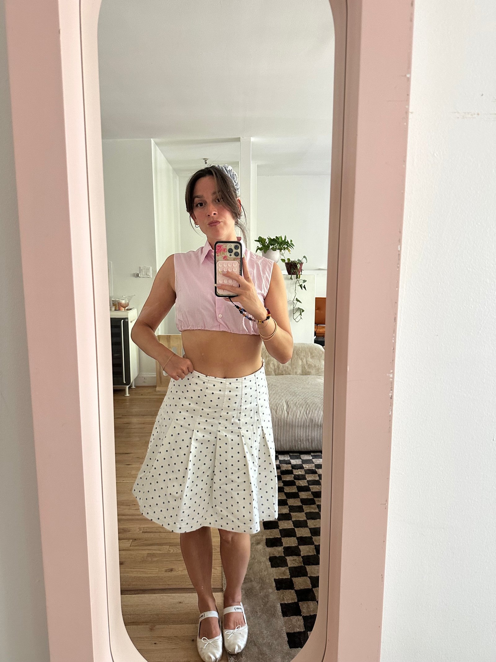 Tara Gonzalez taking selfies in a polka dot skirt.