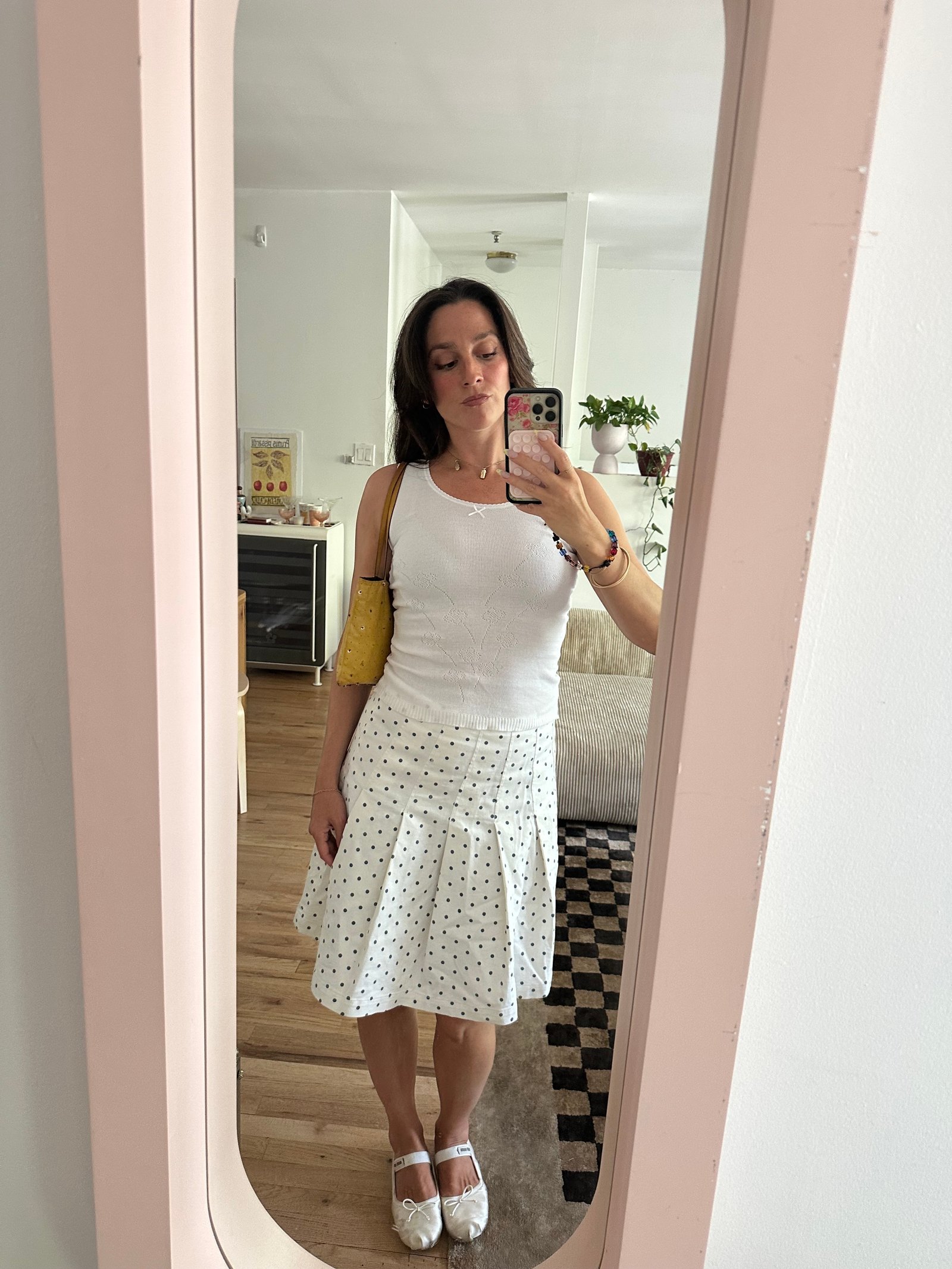 Tara Gonzalez taking selfies in a polka dot skirt.