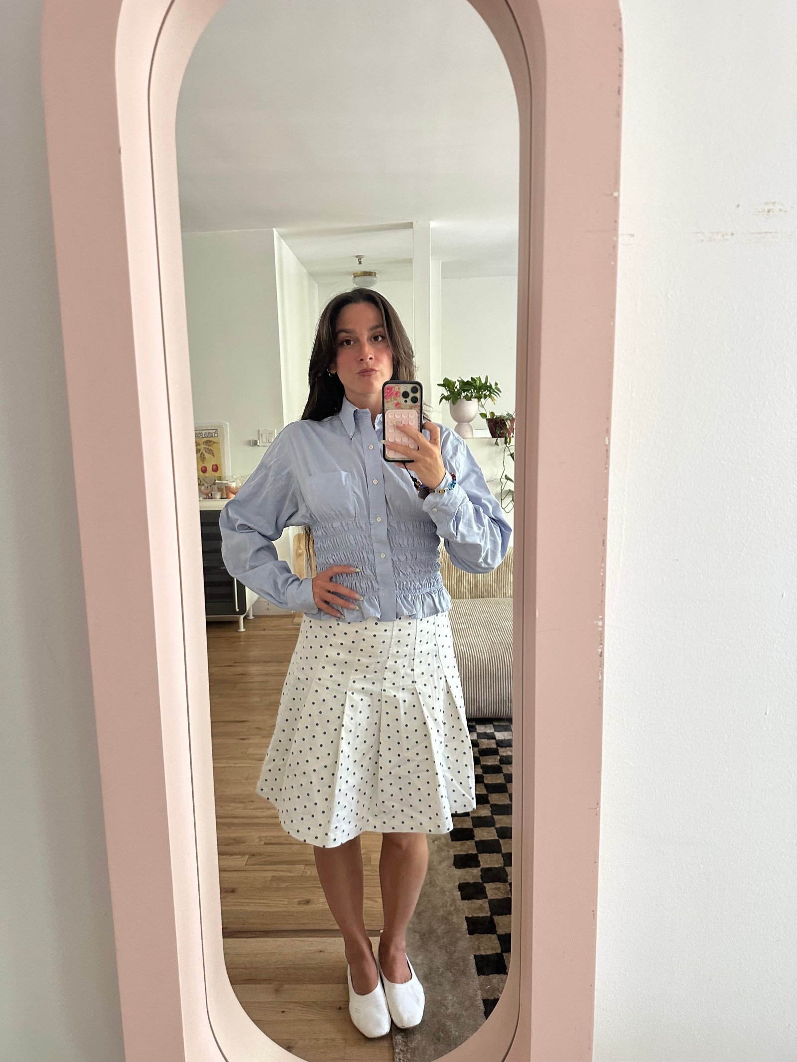 Tara Gonzalez taking selfies in a polka dot skirt.