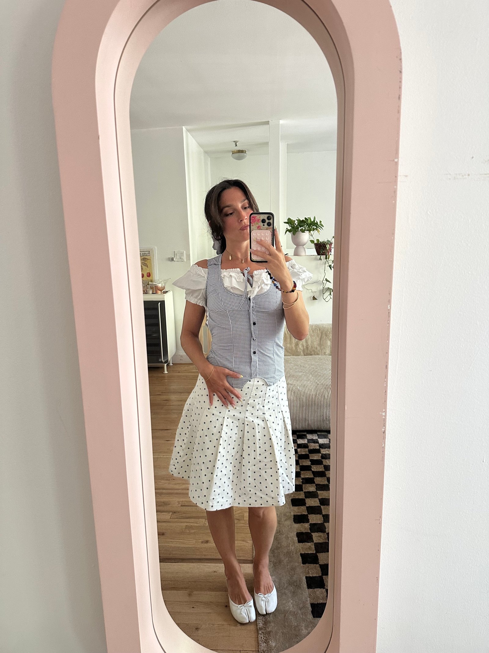 Tara Gonzalez taking selfies in a polka dot skirt.