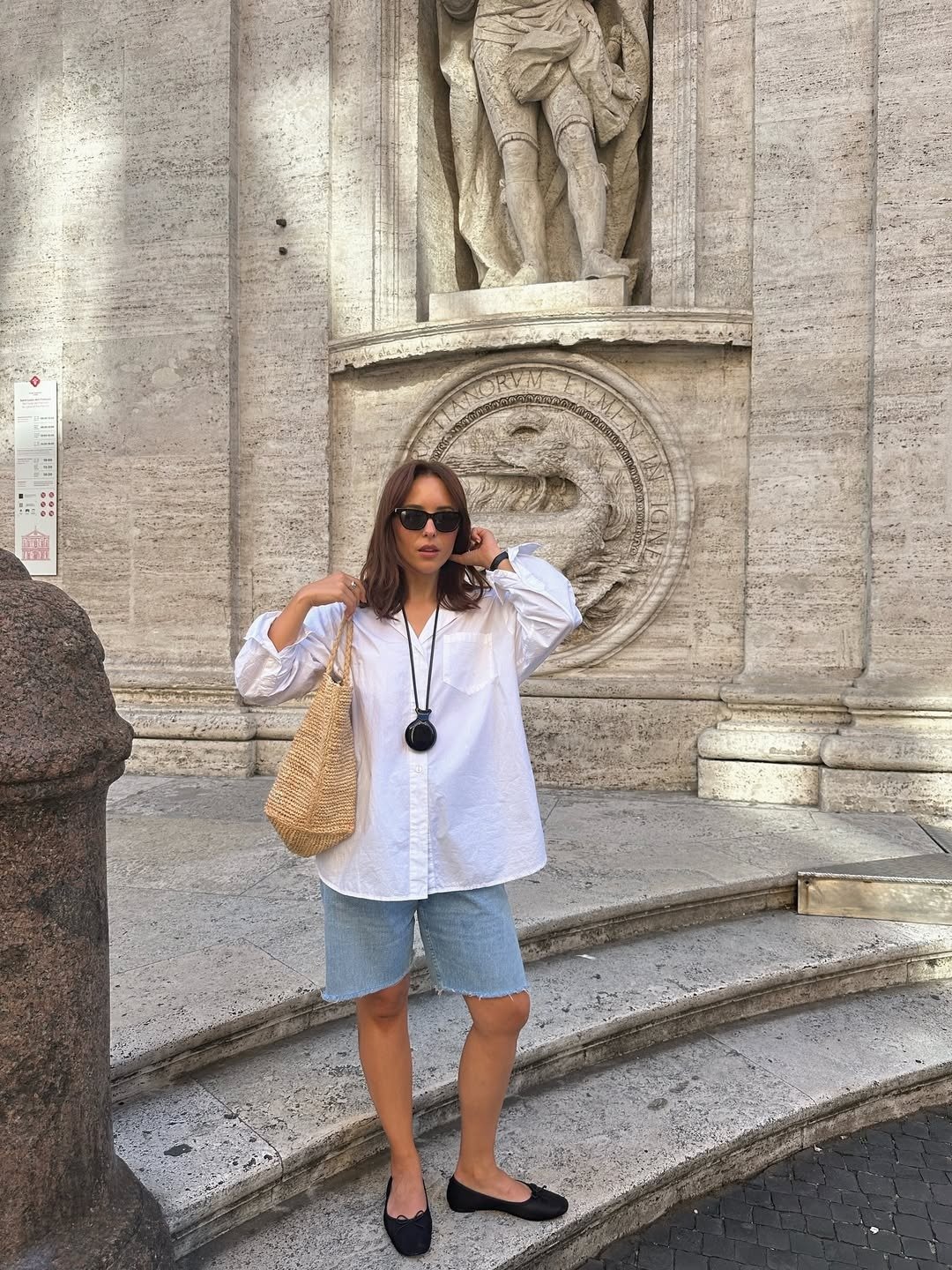Influencer wearing denim shorts with a white button-down shirt and ballet flats