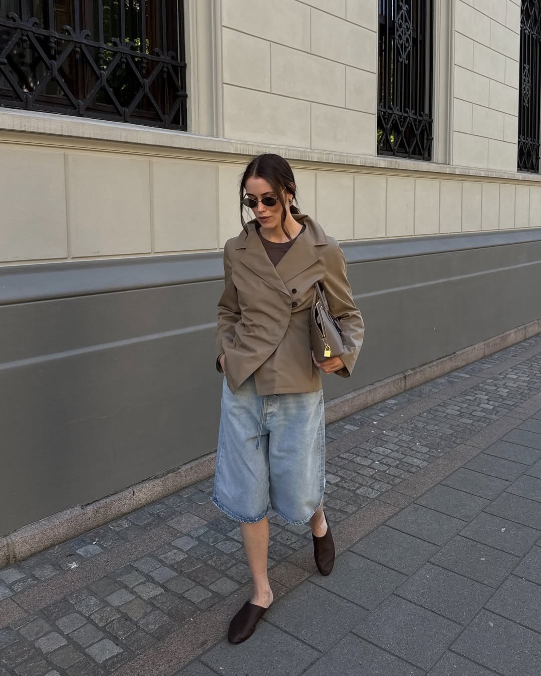 Influencer wearing long denim shorts with a tan blazer and mules