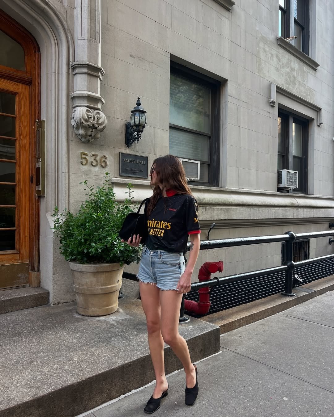 Fashion editor wearing denim shorts with a jersey and high-heel mules