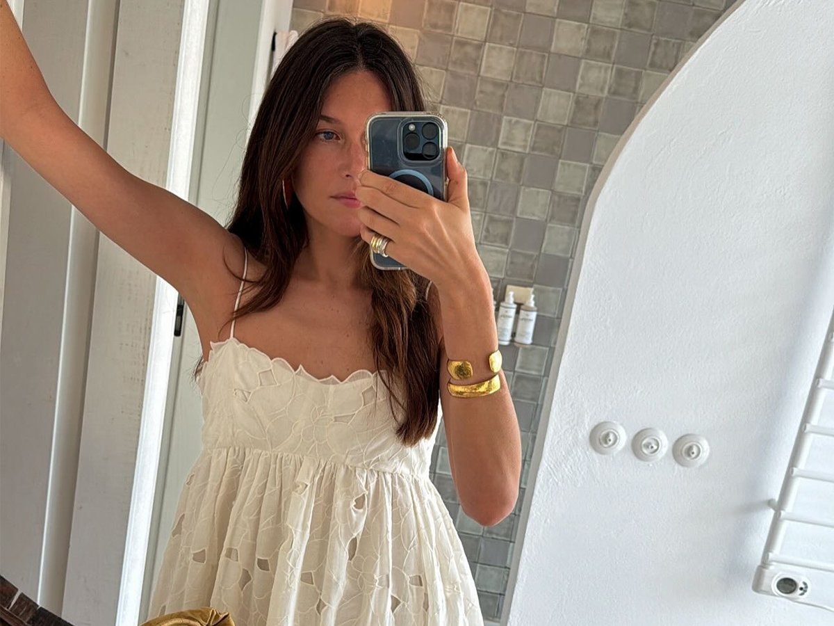 Influencer Sara Ramén wears a white lace dress and a gold bangle.
