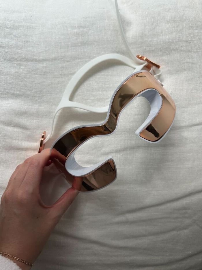 An LED eye mask on a white sheet