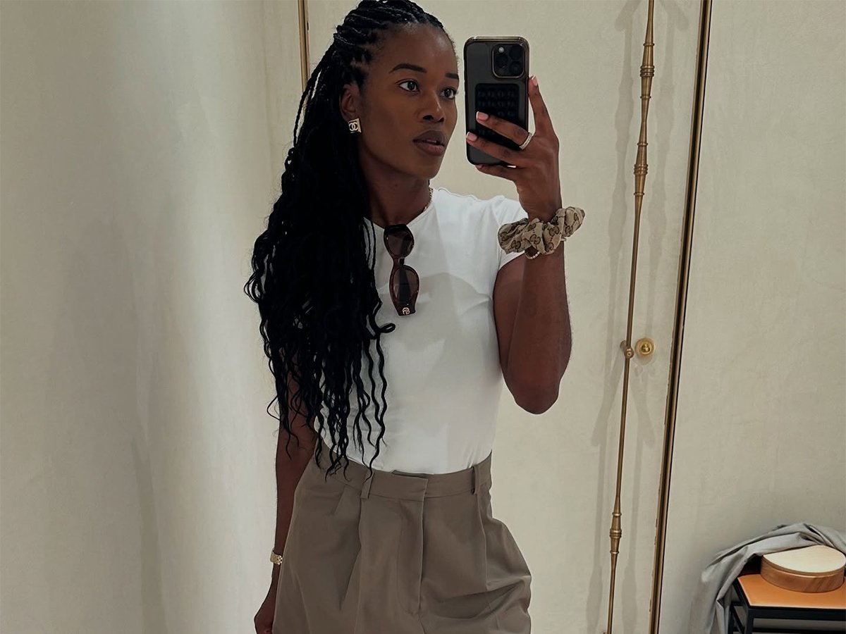 Influencer Marilyn wears a white tee and beige trousers.