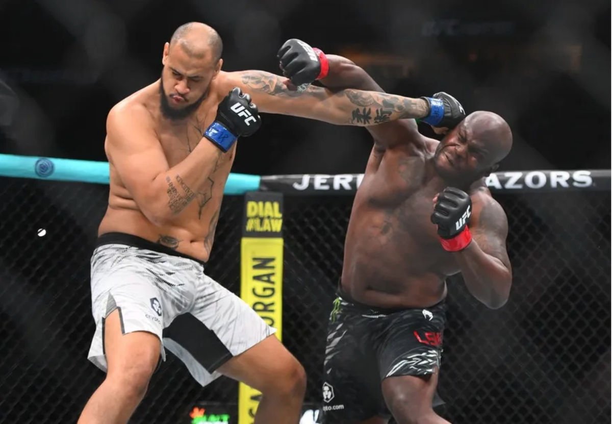 Jul 12, 2025; Nashville, Tennessee, United States; Derrick Lewis (red gloves) fights Tallison Teixeira (blue gloves) in a heavyweight bout during UFC Fight Night at Bridgestone Arena. Mandatory Credit: Steve Roberts-Imagn Images