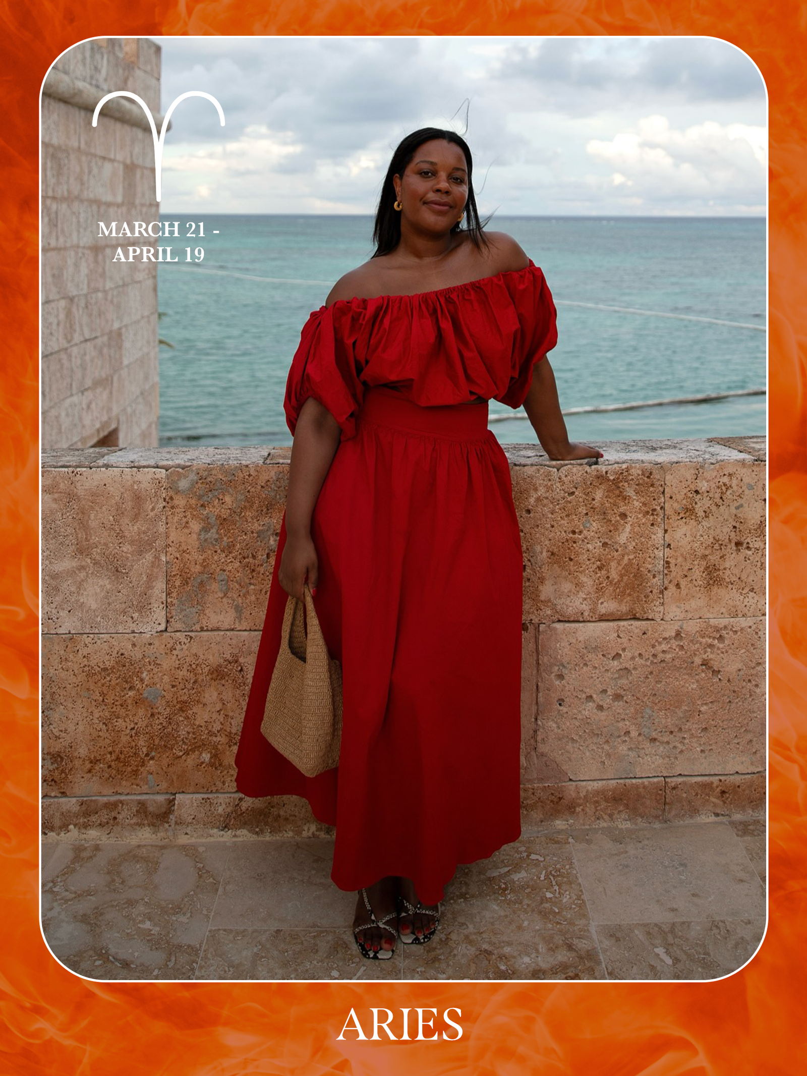 An image of @styleidealist posing on a beach wearing a red dress, showcasing the characteristics of sun sign dressing if you're an Aries.