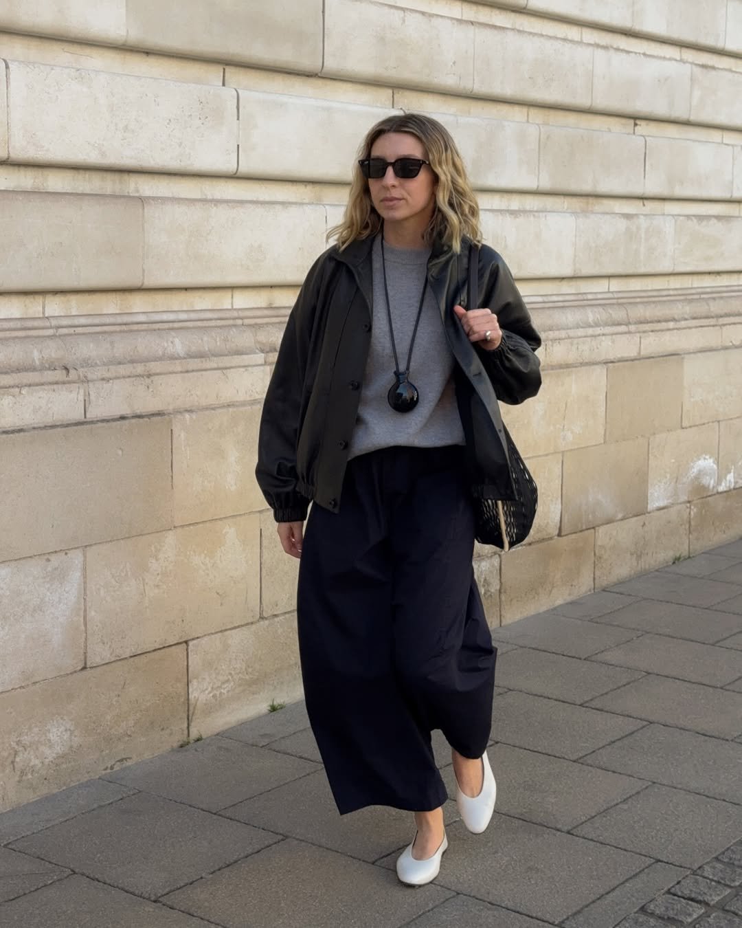 Brittany in black culottes and white flats
