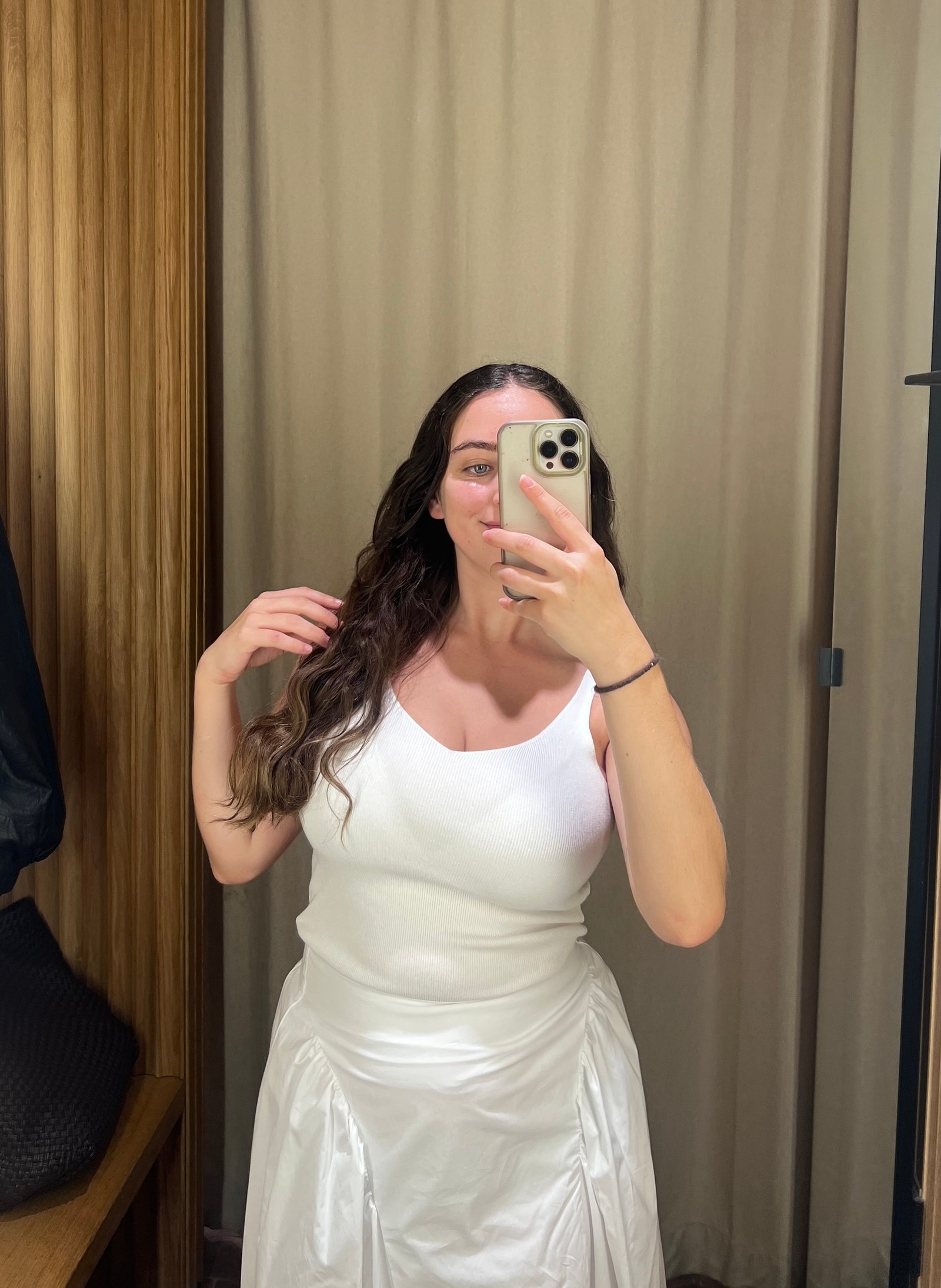An image of Who What Wear's Ava Gilchrist wearing a Mango white tank top with a white cotton skirt.