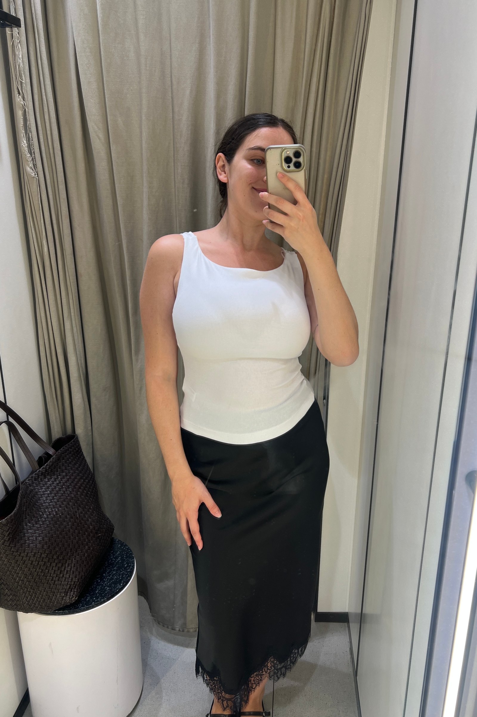 An image of Who What Wear's Ava Gilchrist wearing a Zara tank top with a lace-trim satin skirt.