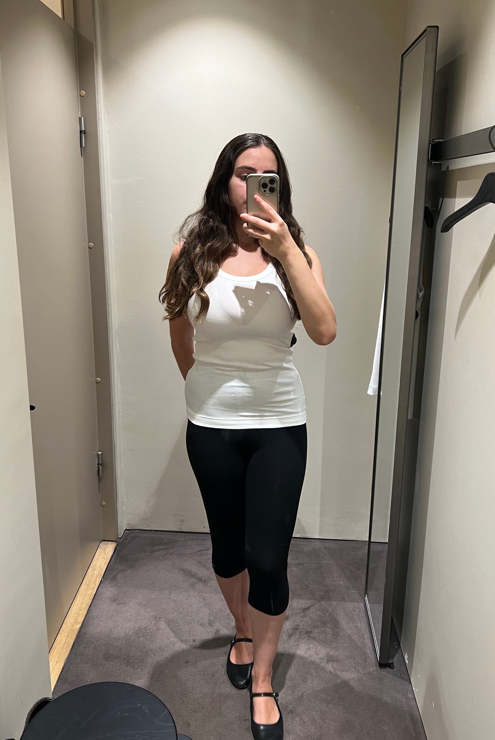 An image of Who What Wear's Ava Gilchrist wearing an COS white tank top with capri pants.