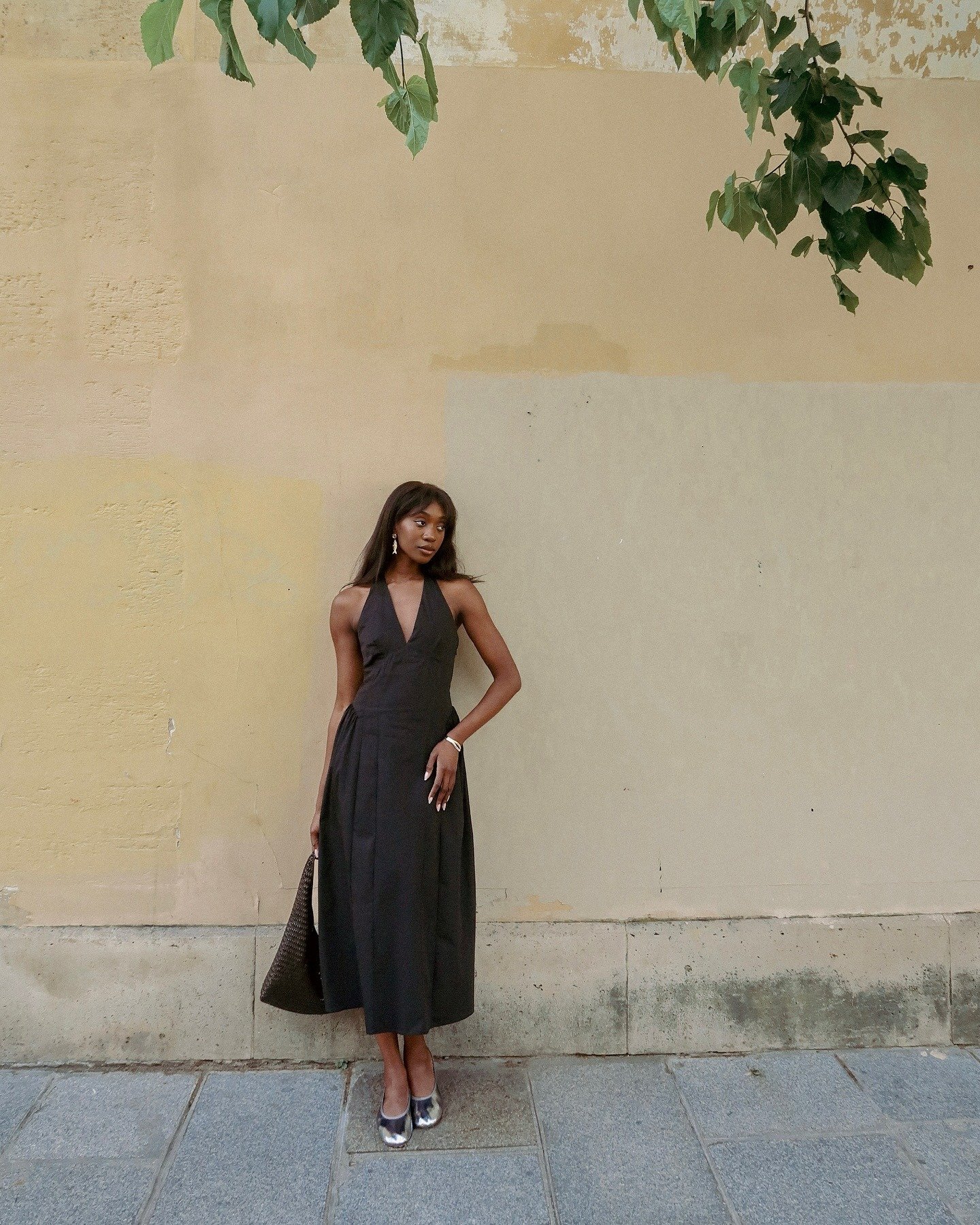 Influencer @emmanuellek_ wears silver ballet flats with a dark brown dress, gold earrings and a brown handbag.
