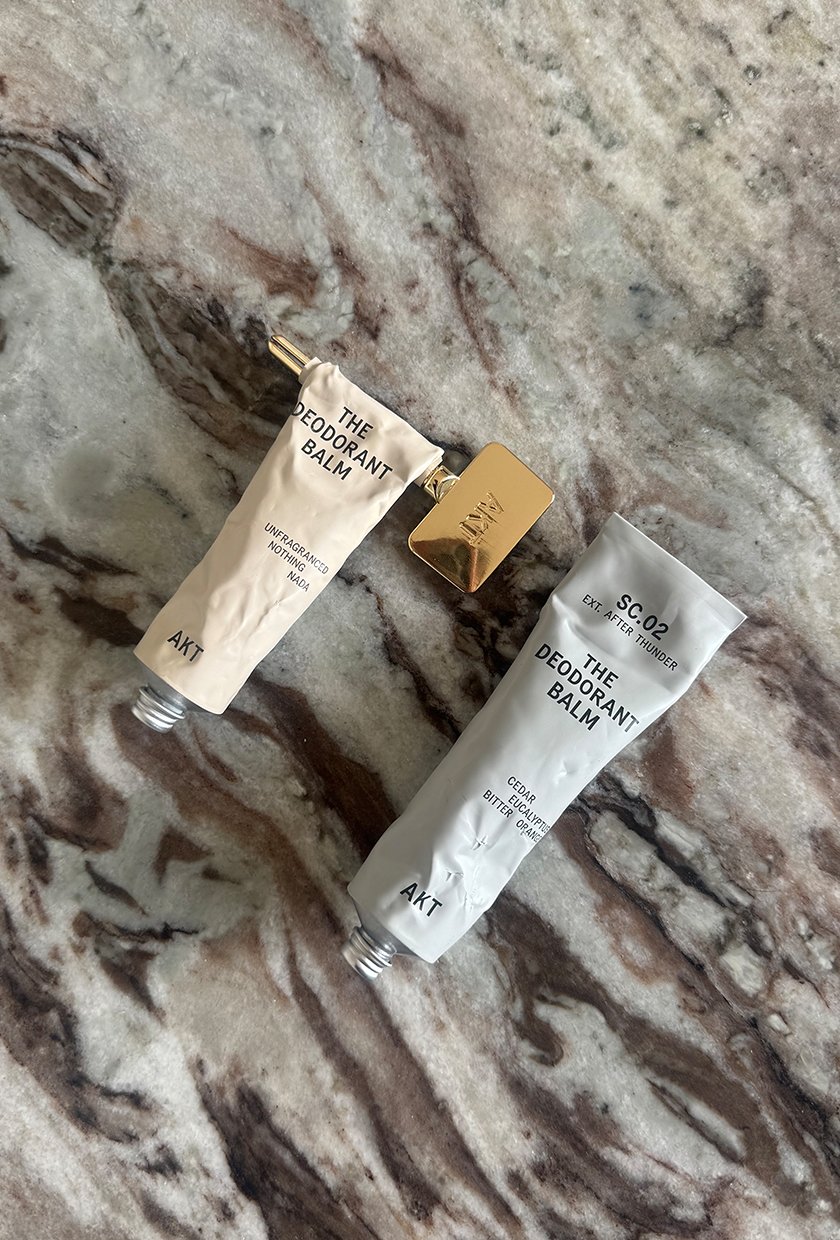 A photo of the AKT London deodorant balms in Unfragranced and After Thunder on a marble table