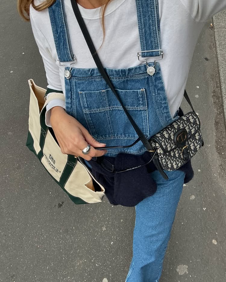 @annelauremais wears denim dungarees with a white long-sleeve top and a Dior crossbody bag