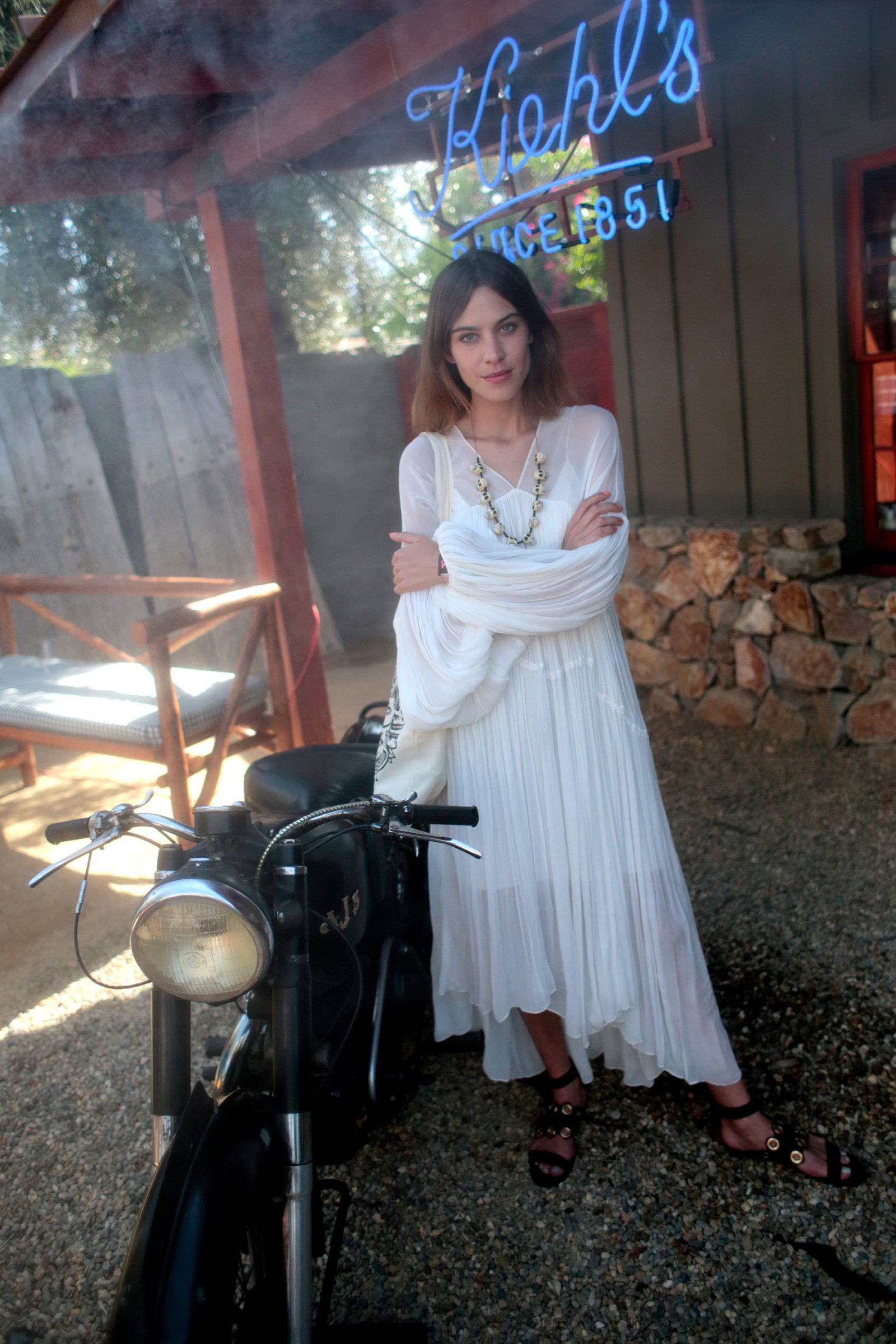 Alexa Chung wears a white boho maxi dress, strappy sandals and a chunky necklace in Palm springs California in 2015.