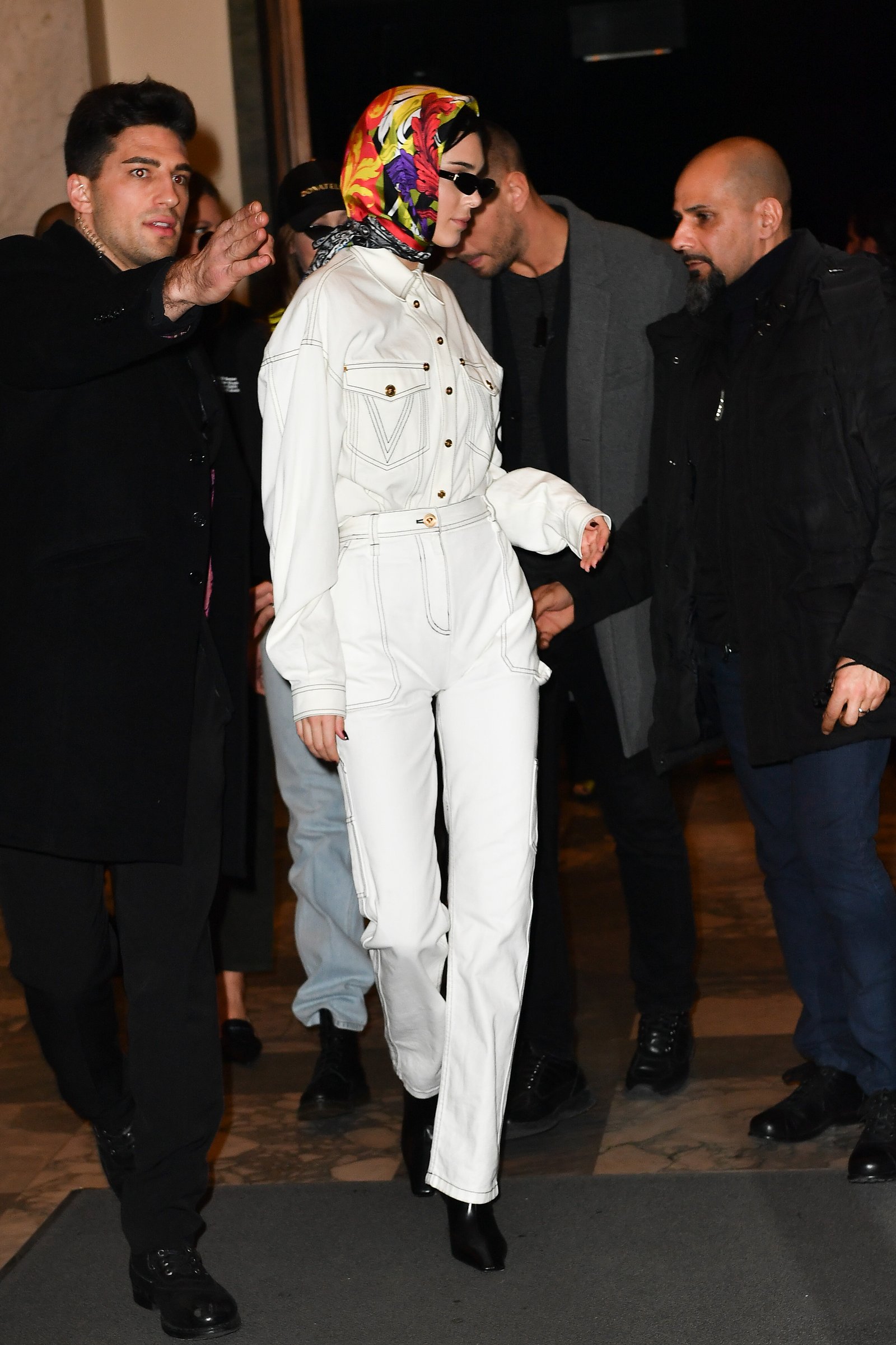 Kendall Jenner wears a silk scarf and double denim ensamble in Milan at the Versace fashion show in a Getty image from 2019.