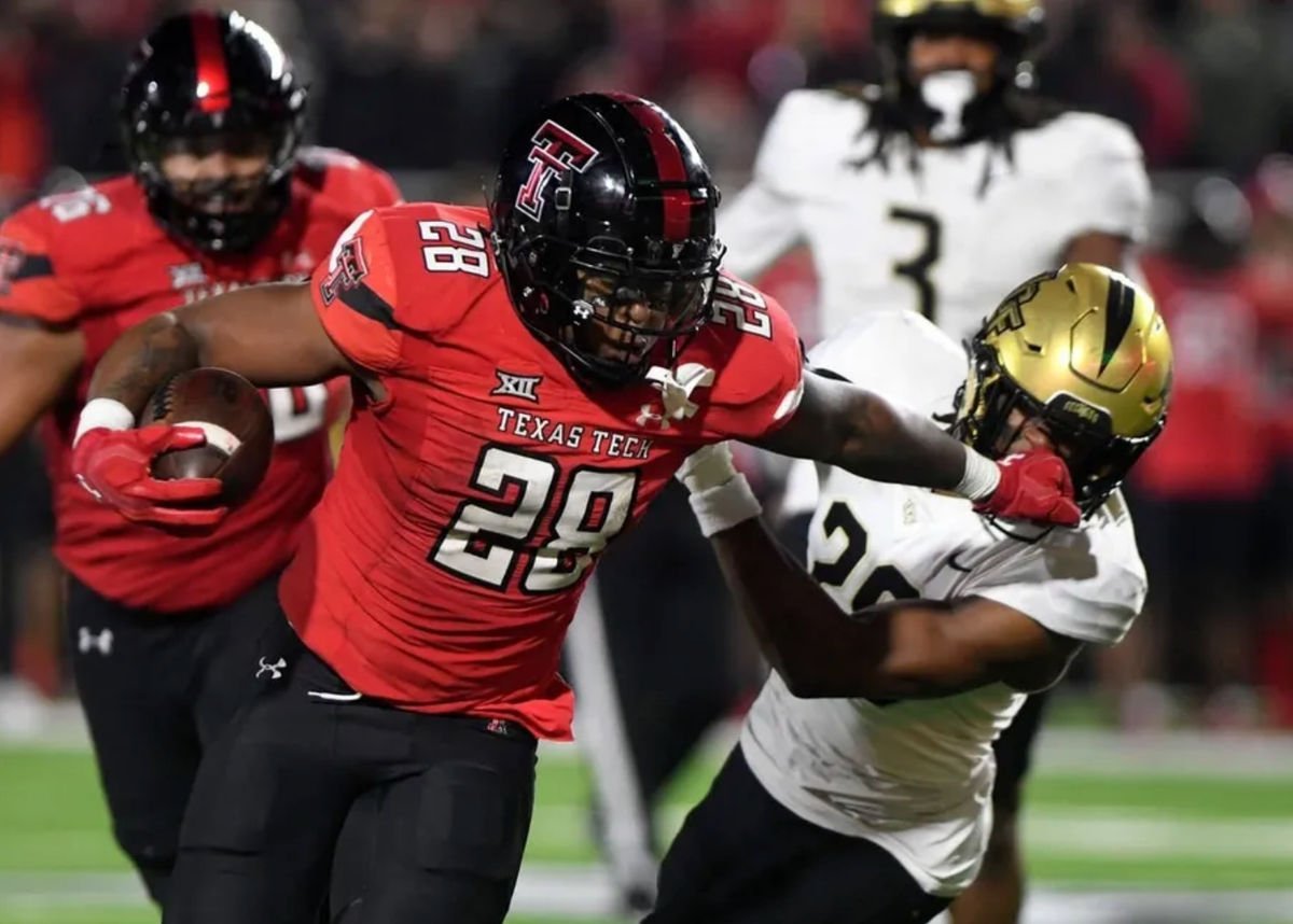 Texas Tech's running back Tahj Brooks (28) stiff-arms UCF's defensive back William Wells (29) during the Big 12 football game, Saturday, Nov. 18, 2023, at Jones AT&T Stadium. credits: Annie Rice/Lubbock Avalanche-Journal / USA TODAY NETWORK