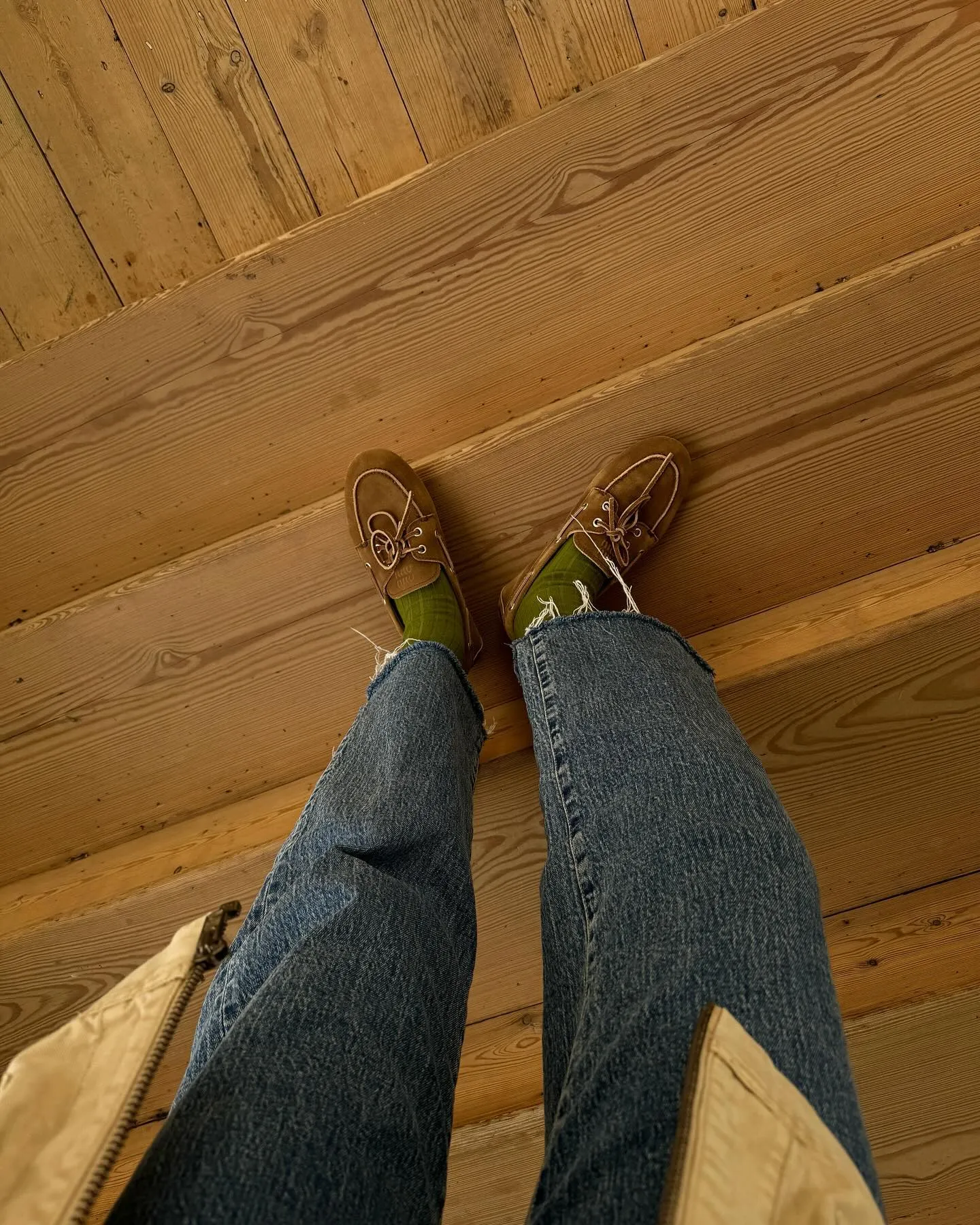 woman wearing blue jeans and suede loafers