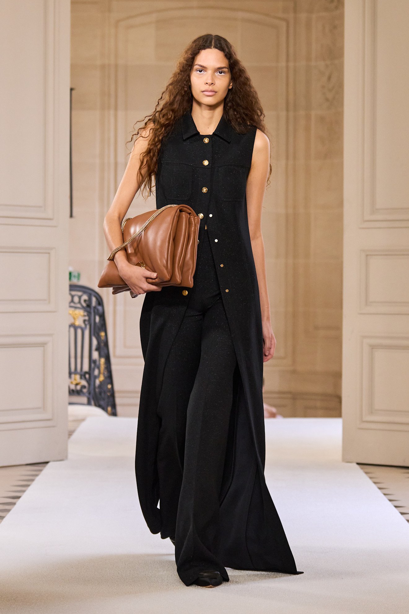 Valli model carrying a camel brown handbag